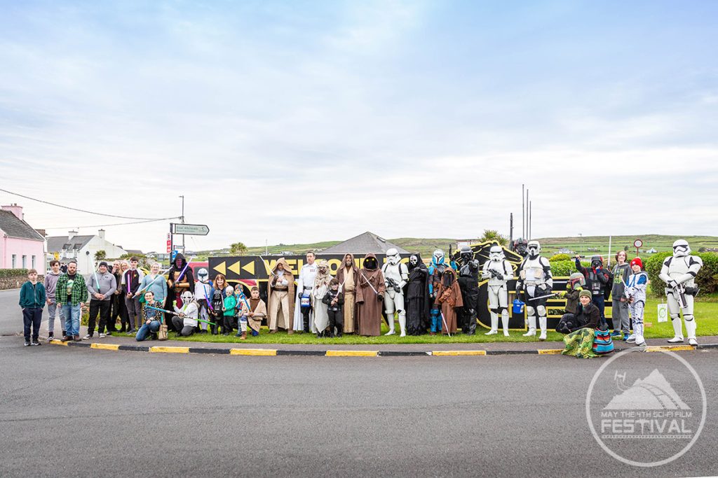 Group photo outside the Welcome sign