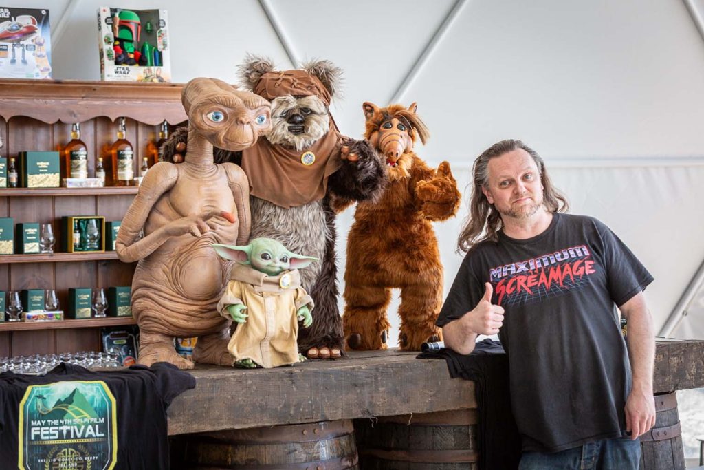 A man posing with Star wars figurines