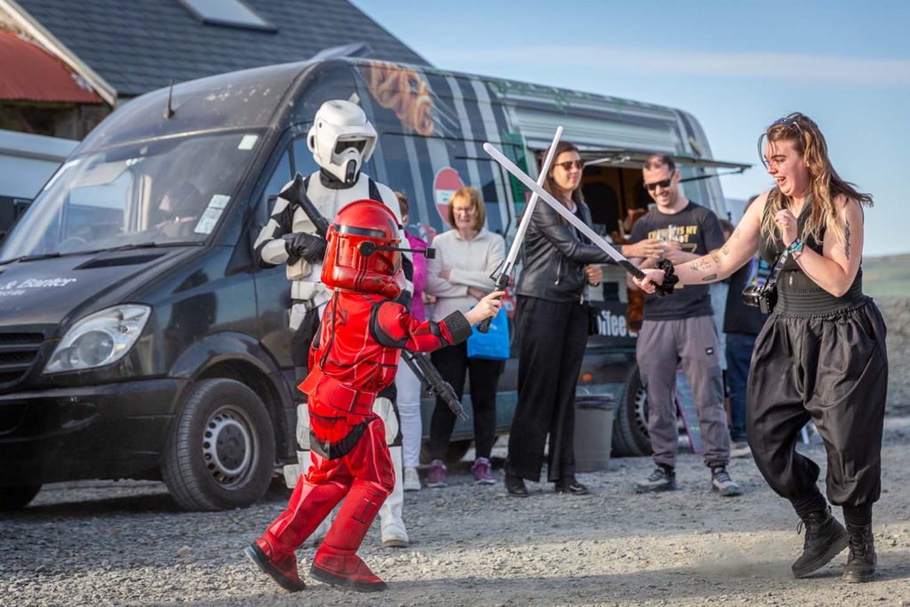 A child having a lightsaber duel with a lady