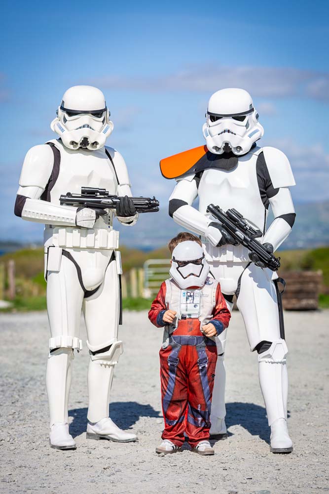 A young child with a storm trooper with orange decorations
