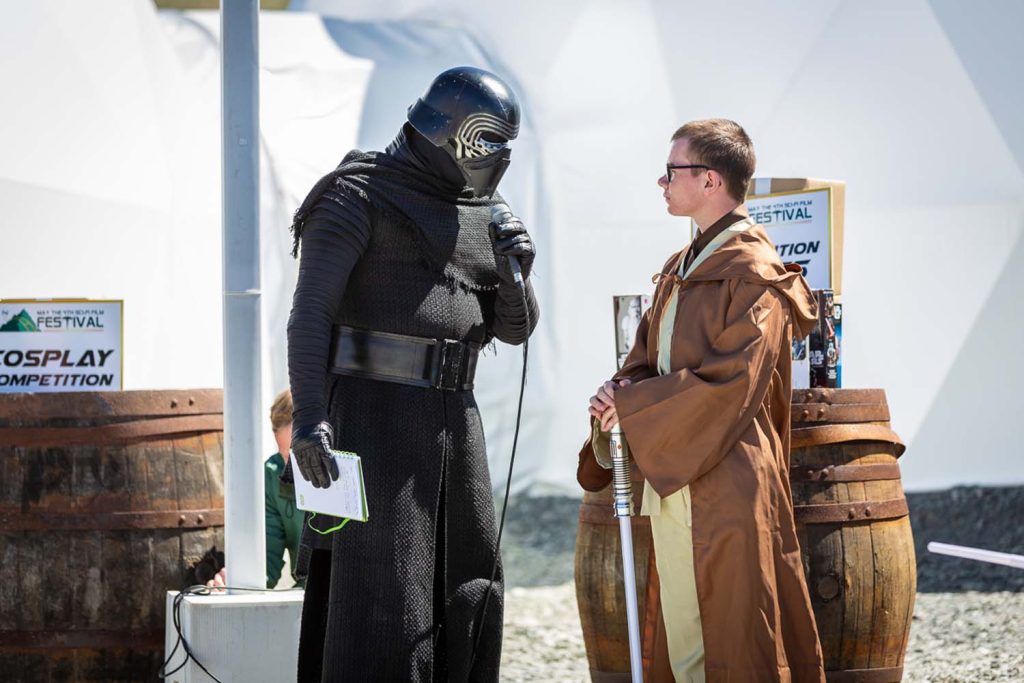 A young boy talking to a star wars character